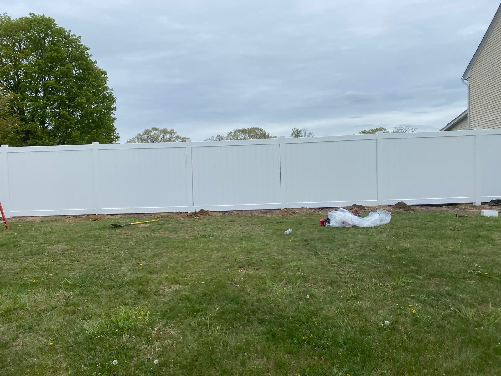 White vinyl privacy fence line installed along a backyard in Bangor, PA