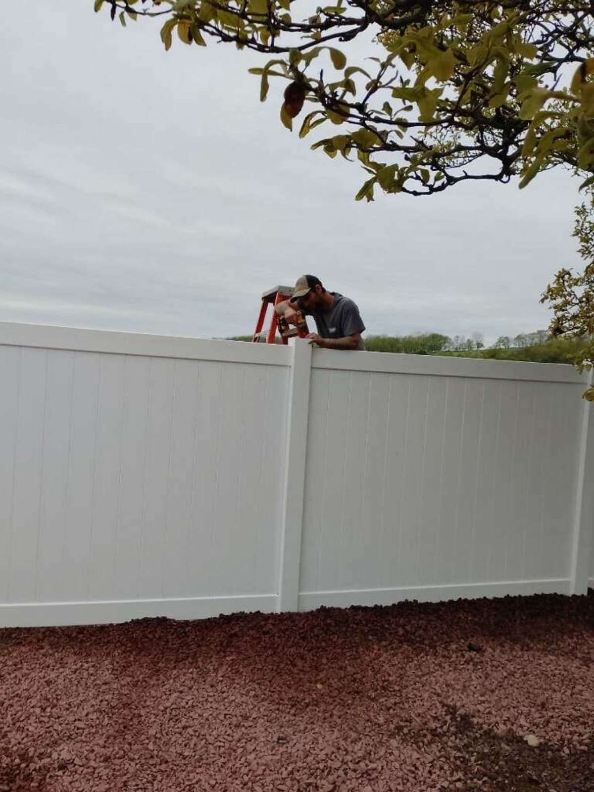 Duckworth Premier Renovations crew setting a vinyl fence panel in Bangor, PA