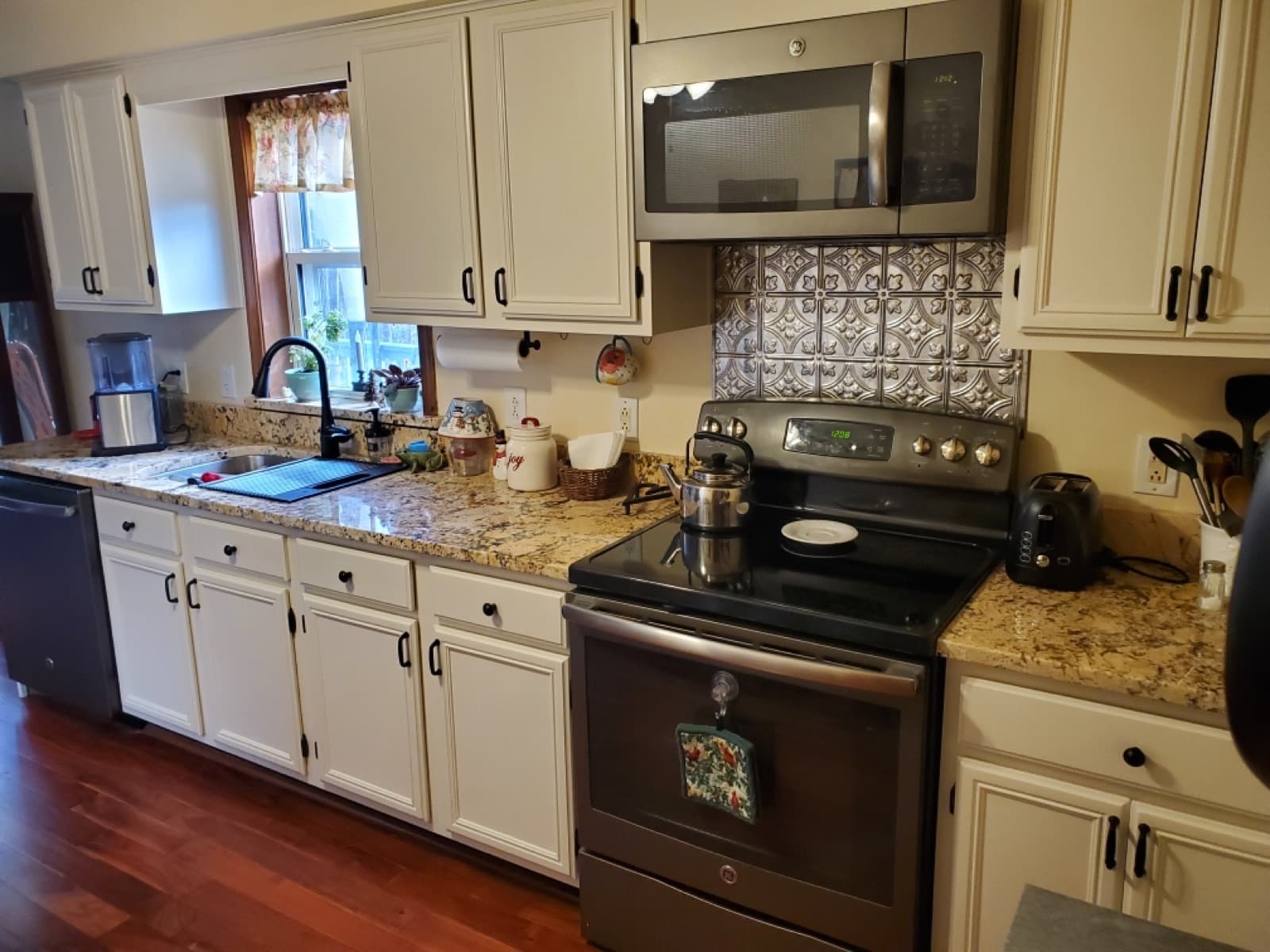 Refinished white kitchen cabinets with granite counters from a Duckworth Premier Renovations refinishing project