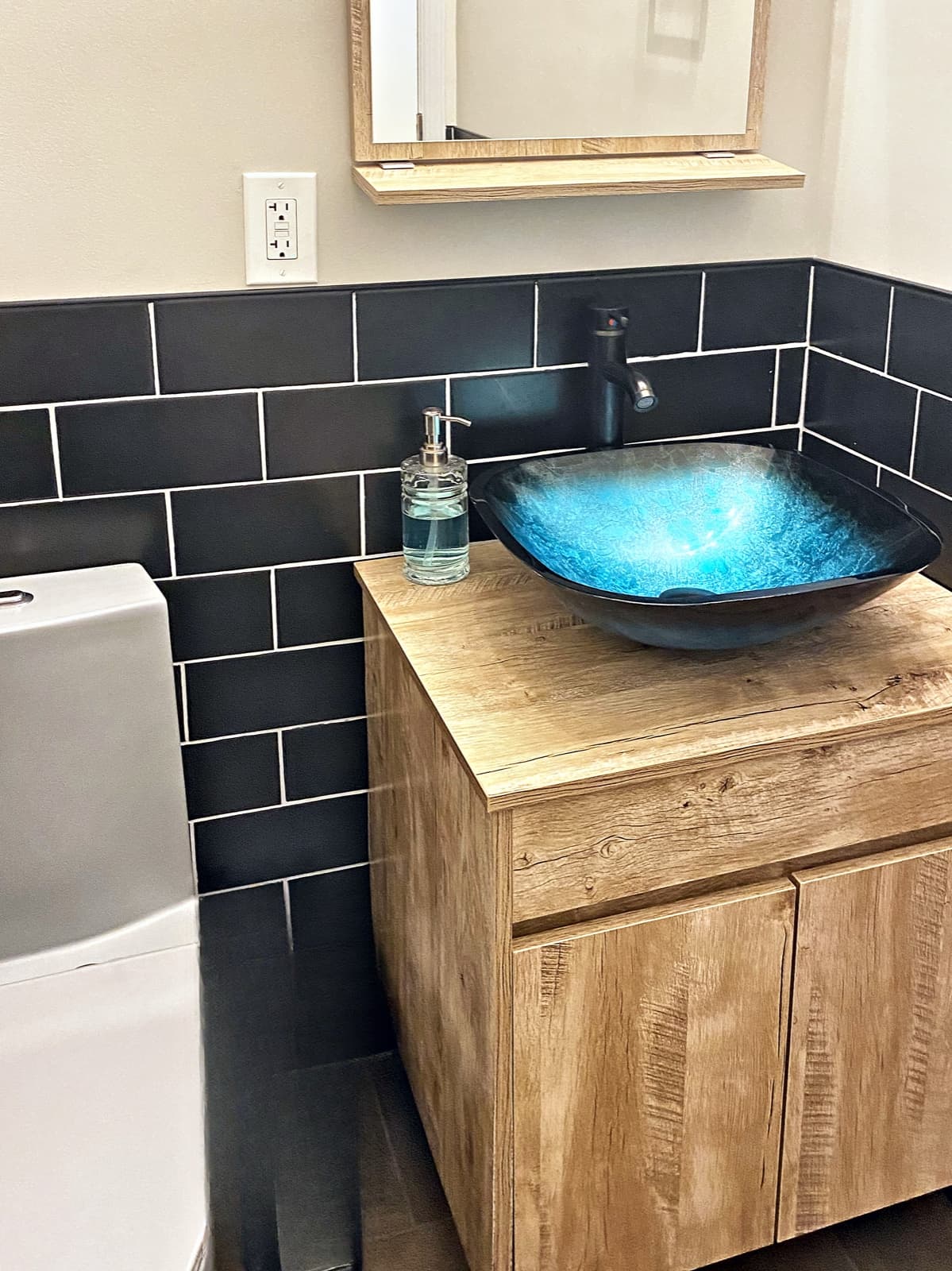 Finished bathroom in Forks Township, PA with black subway tile and a floating vanity