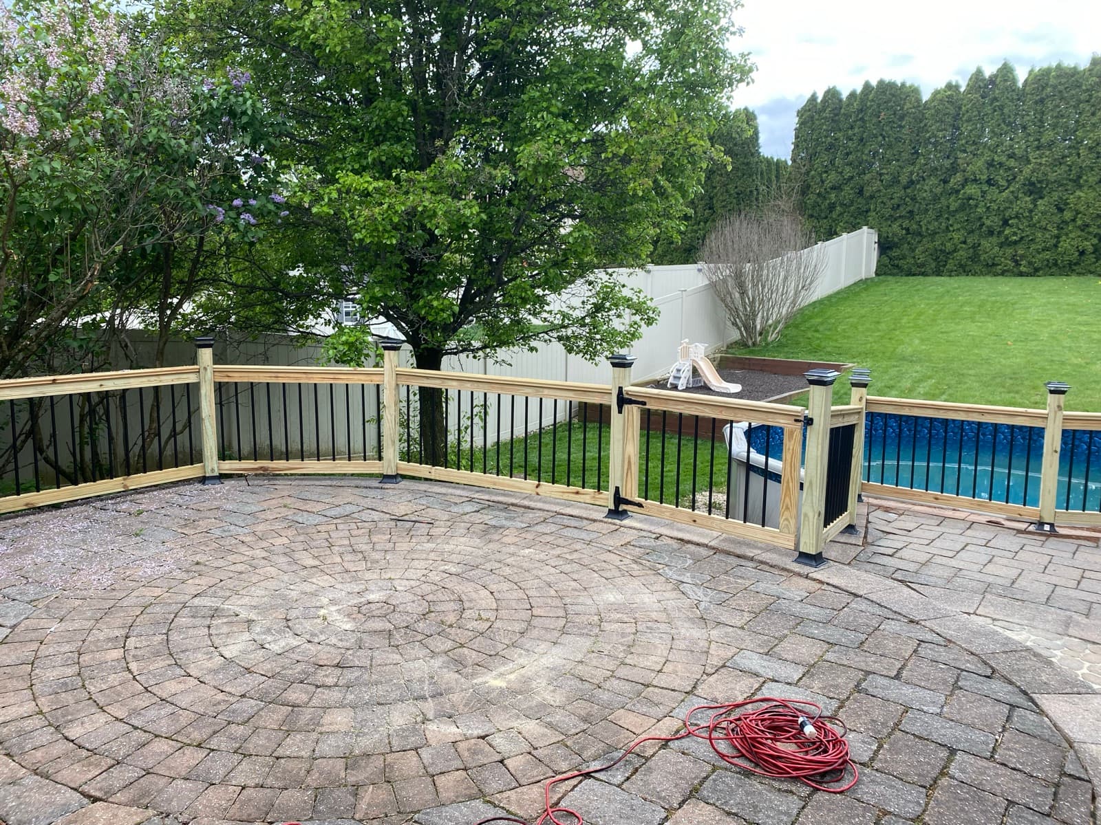 Paver patio and custom railing built around an above-ground pool in Northampton, PA