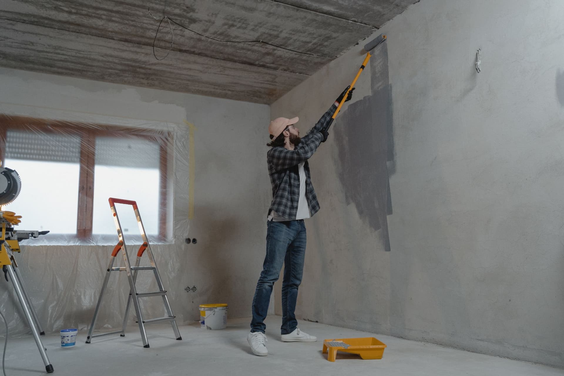 Professional painter rolling a fresh coat onto an interior wall