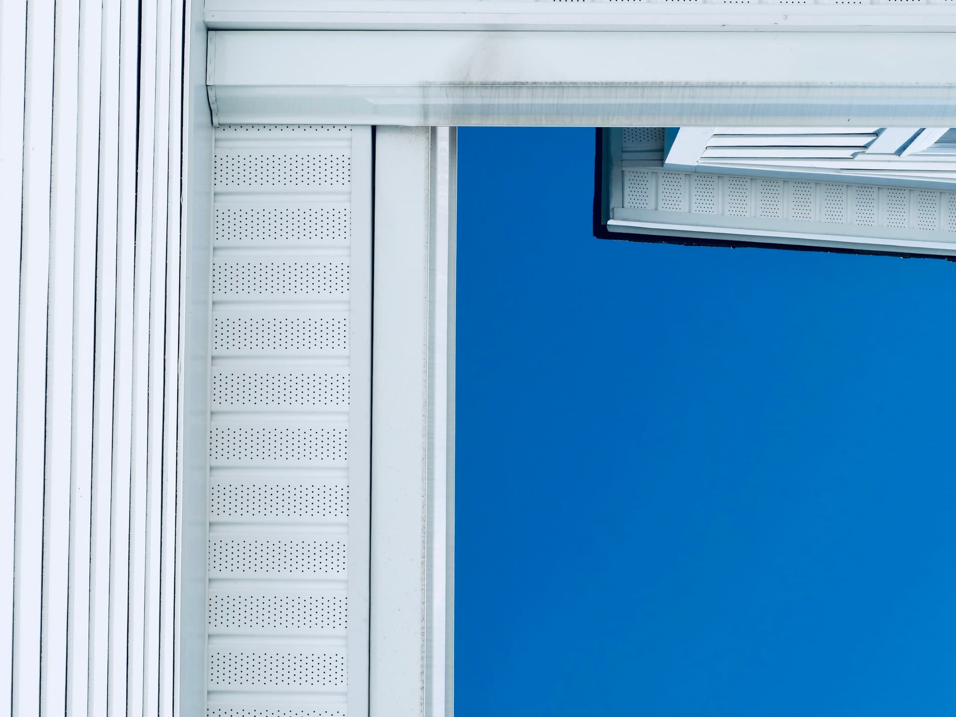 Crisp white siding, soffit, and fascia against a blue sky